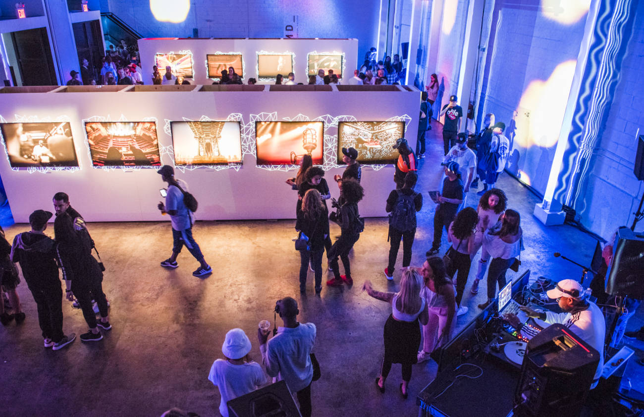 upstairs view of DJ and gallery wall adidas NMD